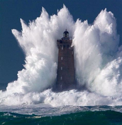 wave crashing over lighthouse.